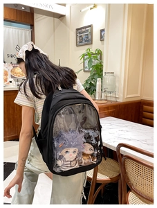 Close-up of black nylon backpack featuring a large transparent PVC pocket for plush toys