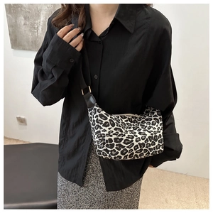 Détail du sac léopard avec bandoulière en cuir noir et finitions métalliques dorées chic