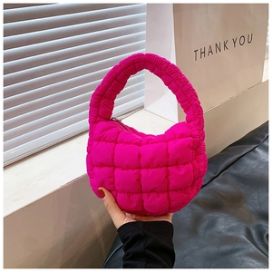 Close-up of bright pink quilted cloud bag featuring soft padded texture and zipper detail