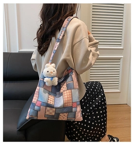 Detail of multi-pattern patchwork canvas tote bag with a cute white rabbit pendant charm