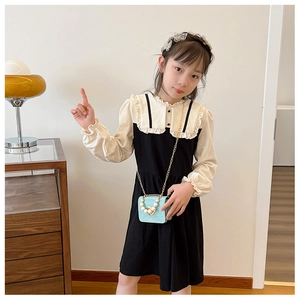 Détail d'une tenue de petite fille avec col à volants et sac à main cœur bleu scintillant