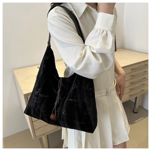Détail du sac cabas en velours noir avec imprimés bambou et perles décoratives ambre