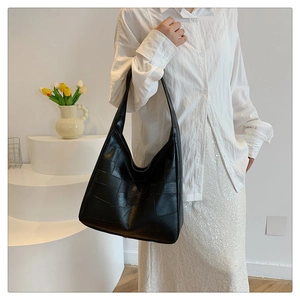 Detail of black geometric patchwork shoulder bag with matte finish for daily commute