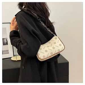 Détail du sac à bandoulière en croissant avec motif monogramme vintage et chaîne dorée