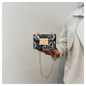 Dettaglio mini borsa leopardata con tracolla a catena dorata e chiusura quadrata in metallo