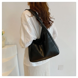 Model view of large black crossbody tote bag with checkered stitching detail