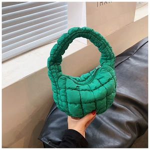 Detail of bright green quilted cloud bag featuring soft padded texture and zipper closure