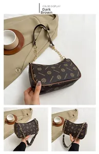 Détail du sac demi-lune marron foncé avec monogramme floral et chaîne dorée