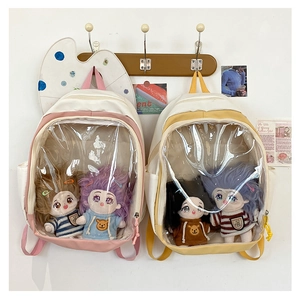 Detail of canvas ita bags with clear PVC windows showing plush doll inserts and decor