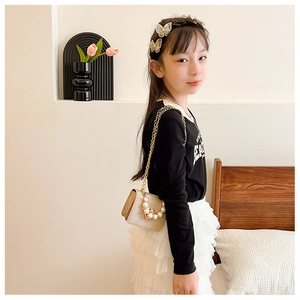 Détail du sac à main pour petite fille avec perles et nœud doré sur bandoulière chaîne