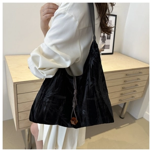 Détail du sac cabas en velours noir avec motifs de bambou et perle de serrage