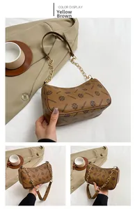 Détail du sac croissant jaune-brun avec bandoulière chaîne et motif vintage élégant