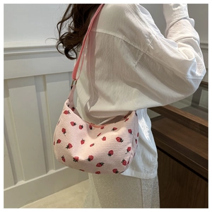 Vue détaillée du sac sous le bras en velours rose avec imprimé fraises sur l'épaule