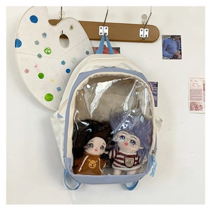 Detail view of ita bag with large transparent window showing plush dolls and blue straps