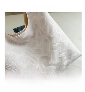 Close-up of the light pink bubble texture fabric and geometric quilted pattern on the bag