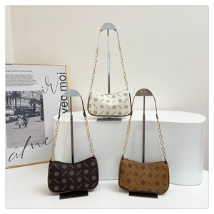 Trois sacs hobo vintage en crème, café et camel présentés sur un support métallique