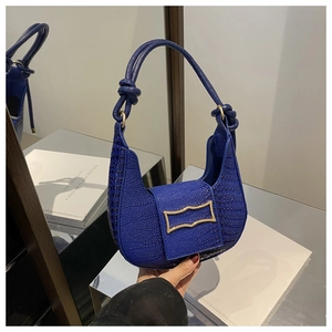 Detail of blue faux crocodile leather bag with gold buckle and knotted shoulder strap