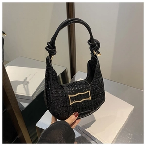 Detailed macro view of black crocodile pattern leather bag with golden metal hardware buckle