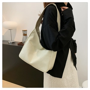 Detail shot of the cream hobo bag with geometric stitching and wide shoulder strap