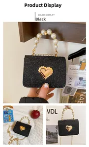 Détails du mini sac à paillettes noires avec anse en perles et fermoir cœur doré