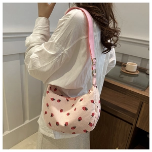Détail du sac à bandoulière en velours côtelé rose avec imprimé fraise et sangle ajustable