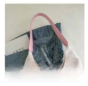 Detail showing white textured tote bag with pink straps and premium stitch finish