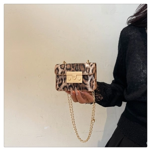 Dettaglio della mini borsa leopardata con chiusura in metallo dorato e tracolla a catena