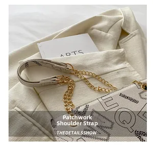 Detailed shot of the shoulder strap with gold metal chain and leather letter print
