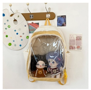Detail of a beige and cream student backpack featuring a clear window for plush dolls