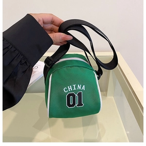 Detail view of mini green canvas crossbody bag with white China 01 lettering and strap