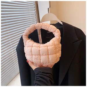 Detail view of light pink quilted cloud handbag showing soft pleated texture and handle