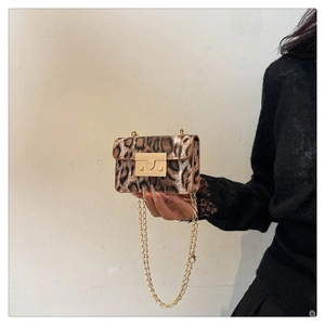 Dettaglio mini borsa leopardata con chiusura dorata e tracolla a catena sottile