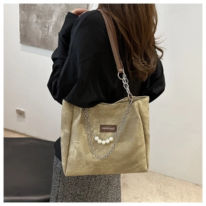 Dettaglio della borsa shopper kaki con catene argentate e ciondolo con perla