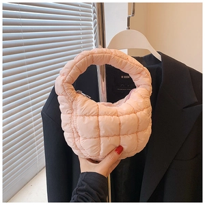 Close-up of pink quilted cloud handbag with soft nylon fabric texture and handles
