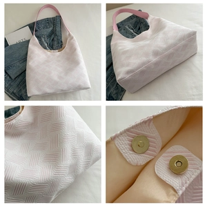 Detail of pink and white jacquard tote bag with geometric texture and magnetic clasp