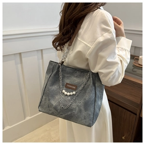 Dettaglio della borsa tote grigia vintage con eleganti perle e accenti di catena