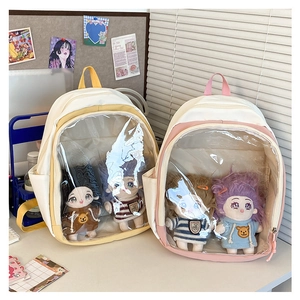 Detail of two-tone ita bags with clear PVC windows displaying plush dolls for travel