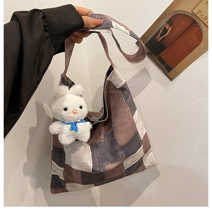 Detailed close-up of large canvas patchwork tote bag with cute white plush rabbit charm