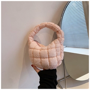 Detail of light pink quilted cloud bag with soft nylon texture and puffy handle