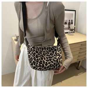 Détail du sac croissant à imprimé léopard avec bandoulière noire sur tenue décontractée