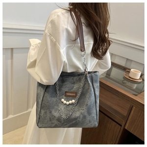 Dettaglio della borsa tote vintage con catena d'argento, perle e tracolla in pelle