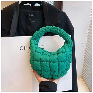 Detailed macro view of the vibrant green quilted texture and puffy stitching on the cloud bag