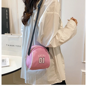 Close-up of pink canvas crossbody bag with white China 01 lettering and zipper detail