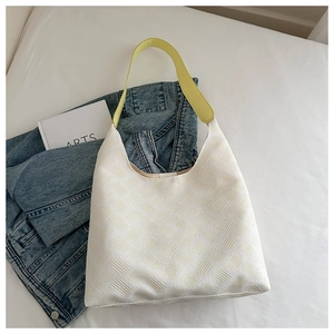 Detail of white woven tote bag featuring contrasting bright yellow shoulder straps