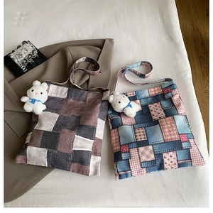 Detail shot of plaid patchwork tote bags with a cute plush rabbit charm on beige fabric