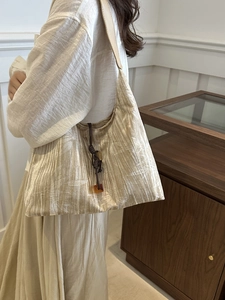 Sac bandoulière vintage plissé couleur champagne avec détail de gland tissé élégant