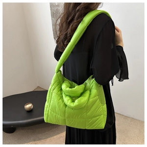 Detail view of neon green quilted tote bag showing padded nylon texture and shoulder strap