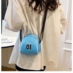 Detail view of light blue mini sports crossbody bag with CHINA 01 embroidery and black strap