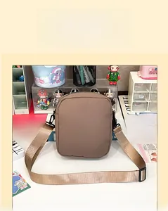 Detail view of durable brown nylon crossbody bag with adjustable wide woven shoulder strap