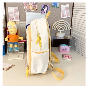 Detail of yellow and white canvas backpack with side pocket on a desk with decor